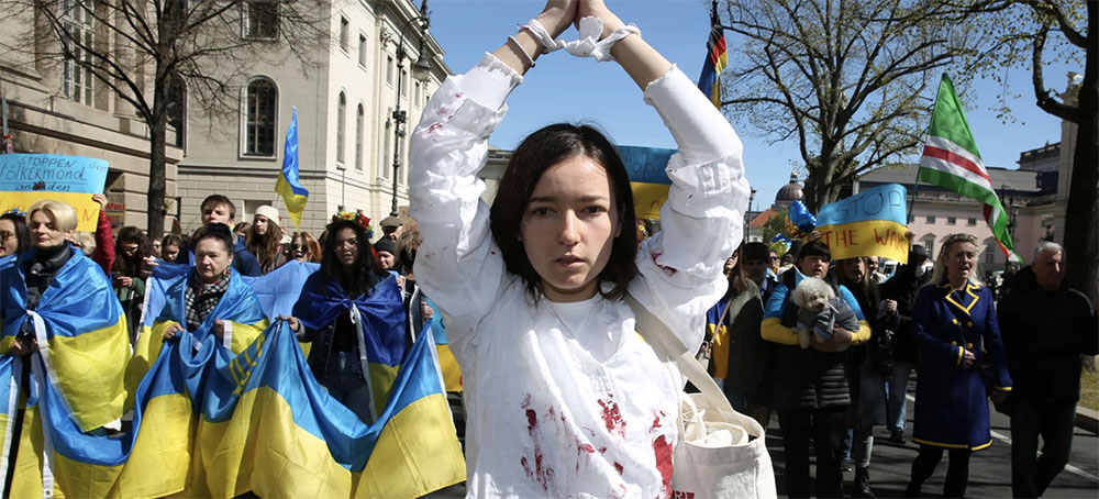 A woman representing a rape victim leads protesters in Berlin demonstrating in an April 16 march against Russian military aggression in the ongoing wars in Ukraine and Syria.
(photo: Adam Berry/Getty Images)
