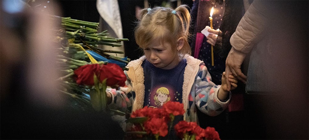 A little girl at a memorial. (photo: SAMSONOV)