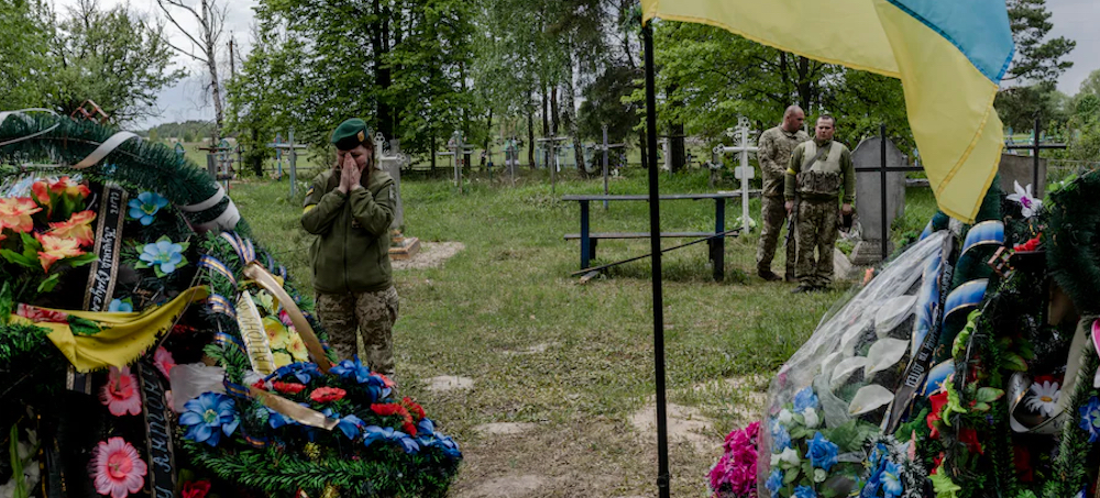 Andriy Samusenko and Anton Myahkyi's fellow border guards lay flowers on their graves in Tykhonovychi on May 17. (photo: Kasia Strek/WP)