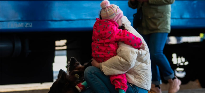 A woman holds a child and dogs on a train platform after arriving from Mariupol. (photo: Ty O'Neil/SOPA Images/Getty Images)