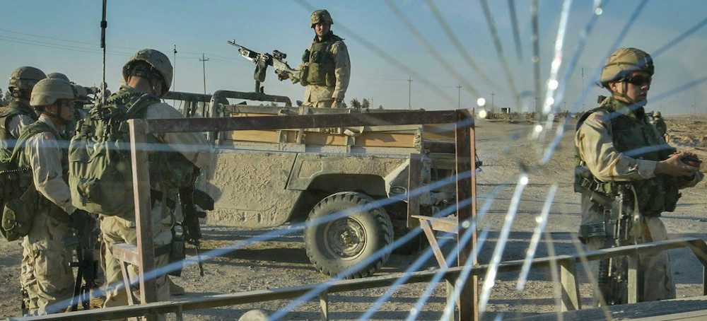 U.S. soldiers with the 82nd Airborne Division patrol at a coalition checkpoint in Fallujah, Iraq, Nov. 20, 2003. (photo: Anja Niedringhaus/AP)