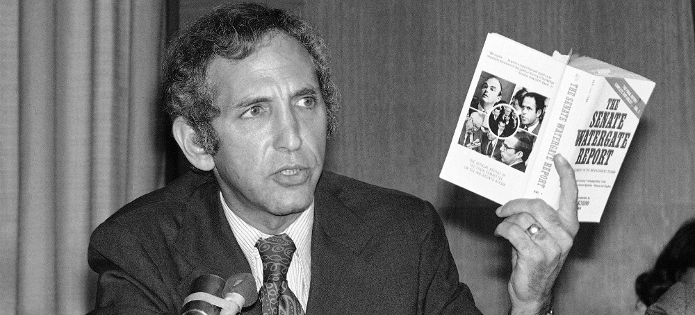 Daniel Ellsberg, the whistleblower who leaked the Pentagon Papers figure, holds up a copy of a book entitled 'The Senate Watergate Report' as he appears as a panelist at a conference on the Central Intelligence Agency and covert activities, Sept. 13, 1974, in Washington. (photo: Henry Griffin/AP)