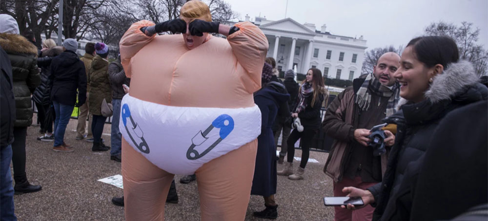 A demonstrator wearing a mask depicting President Donald Trump pretends to cry near the White House following the 2019 Women's March on January 19, 2019, in Washington, D.C. (photo: Zach Gibson/Slate)