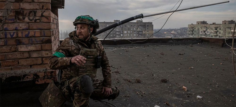 A Ukrainian junior sergeant with the call sign Bandit on top of a destroyed building on Tuesday. Ukrainian and Russian armed forces are fighting bloody battles in the ruined eastern city of Bakhmut. (photo: Ed Ram/WP)