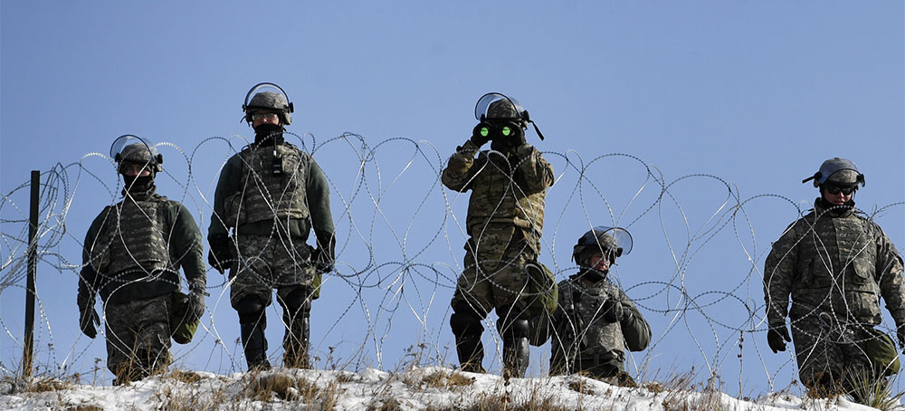 National Guard members stand on Turtle Island watching activists at Oceti Sakowin Camp, Standing Rock Sioux reservation on Dec. 3, 2016, in North Dakota. (photo: Helen H. Richardson/The Denver Post)
