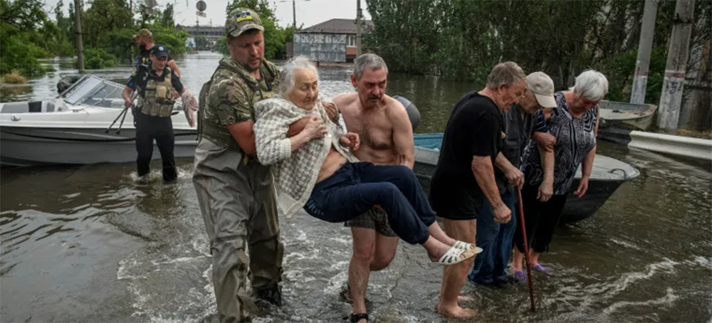 Rescuers evacuate local residents from a flooded area after the Nova Kakhovka dam breach, in Kherson, Ukraine, June 7, 2023. (photo: Vladyslav Musiienko/Reuters)
