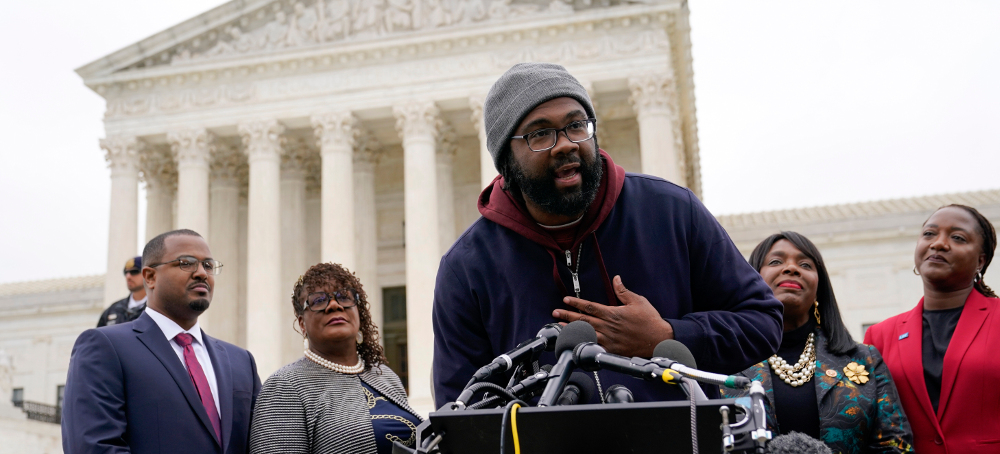 Evan Milligan, plaintiff in Allen v. Milligan, speaks to members of the press after the oral arguments for the Merrill v. Milligan case at the U.S. Supreme Court on Oct. 4, 2022, in Washington, D.C. (photo: Patrick Semansky/AP)