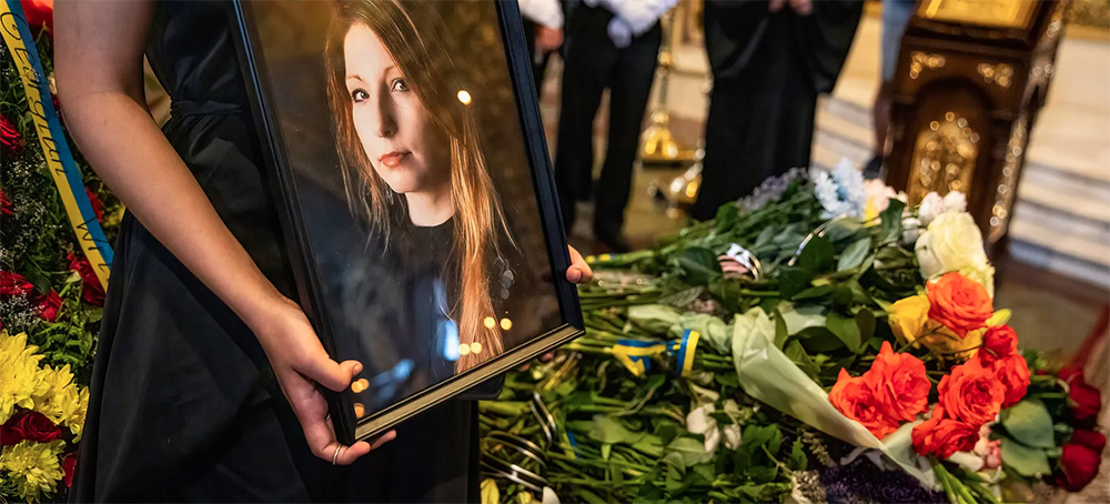 A person holding a photograph of a woman at a funeral. (photo: Alex Chan Tsz Yuk/Getty Images)