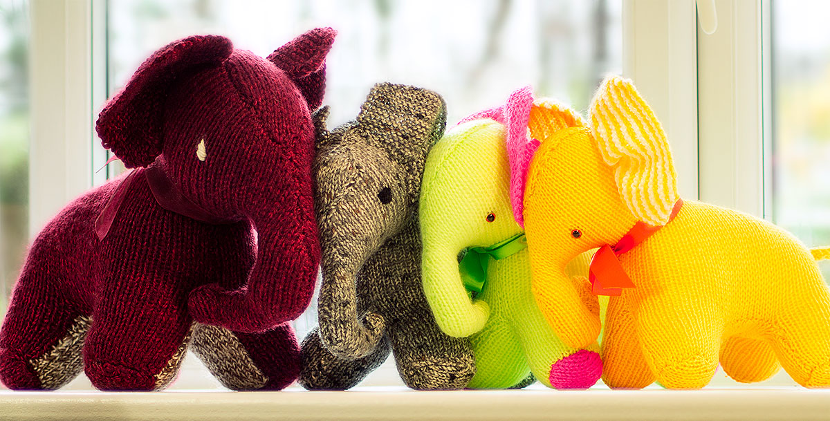 A herd of hand knitted elephants in colourful wool