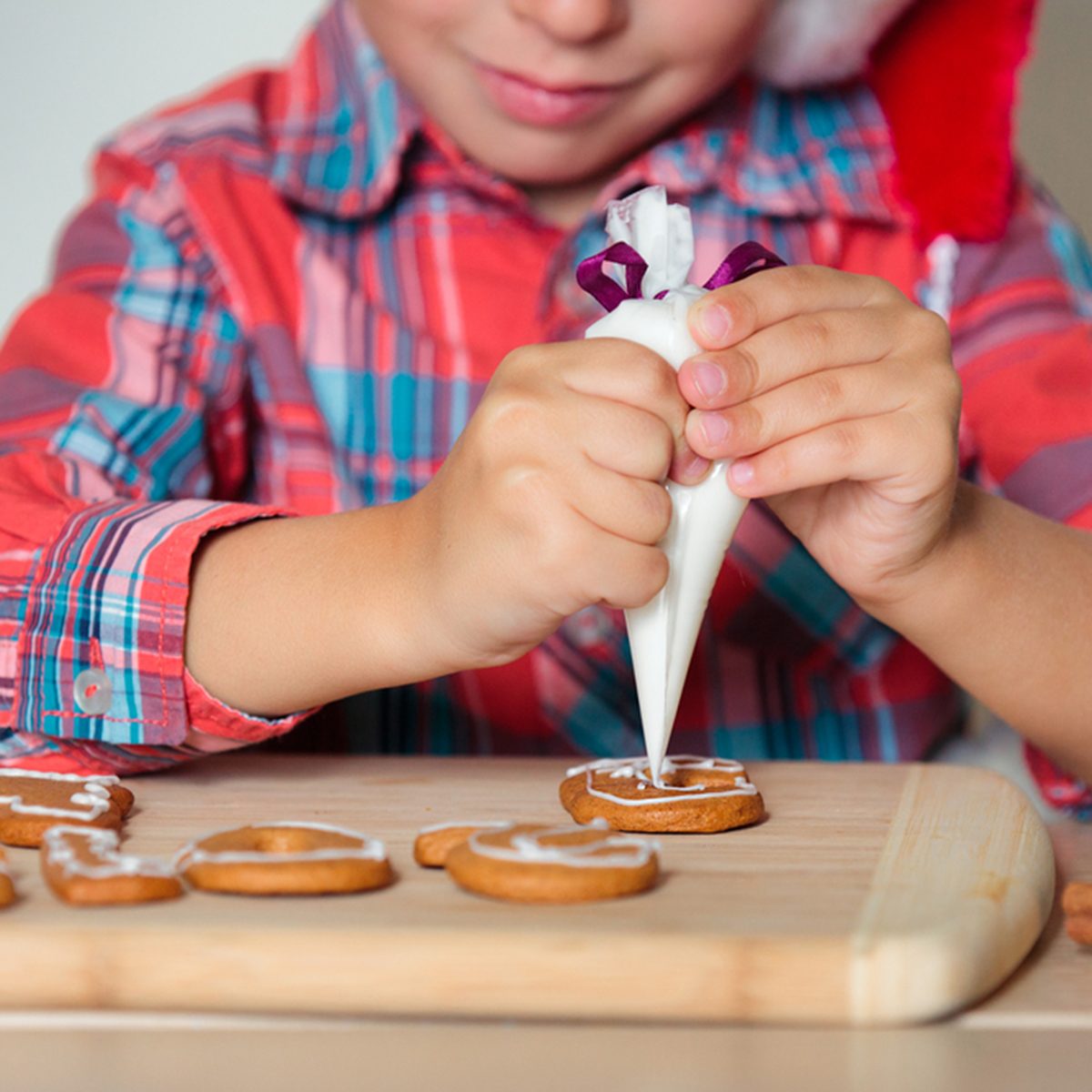 Close up of kid decorating the gingerbread cookies