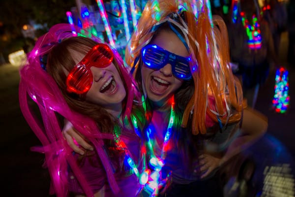 Pair of Students Smiling for Photo with Glow Merchandise - Universal's Grad Bash & Gradventure